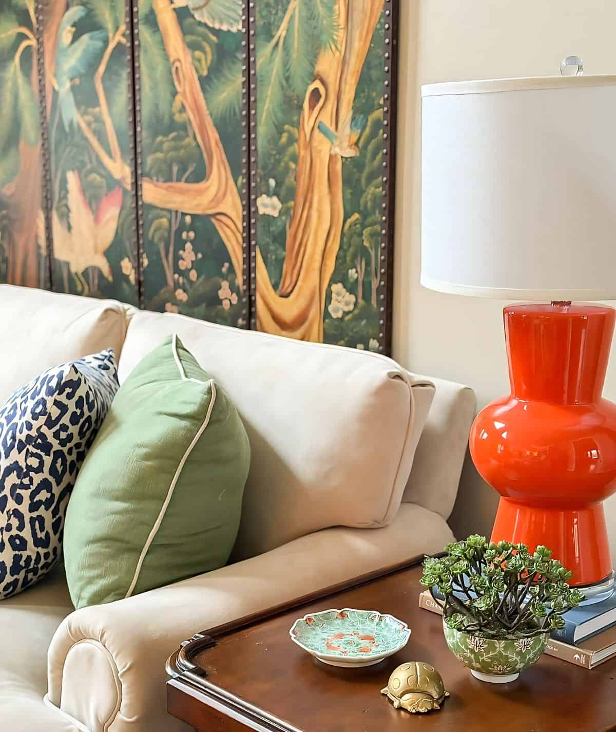 modern orange base lamp beside traditional furniture and accessories