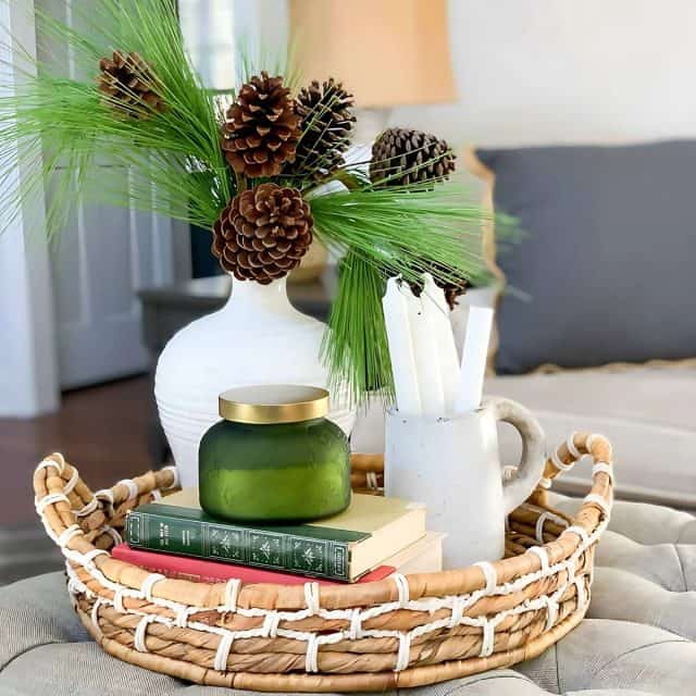 winter vignette in a round tray on an upholstered coffee table