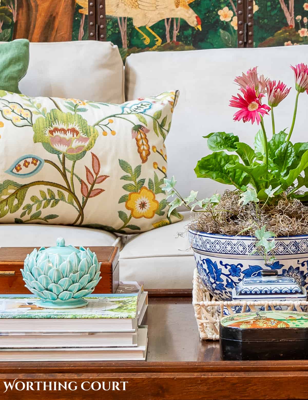 coffee table in front of a beige sofa with summer accessories