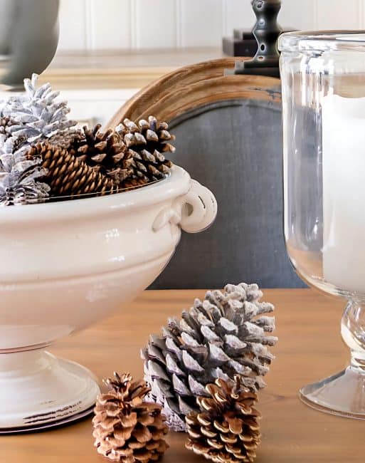 white pedestal bowl filled with snowy pine cones