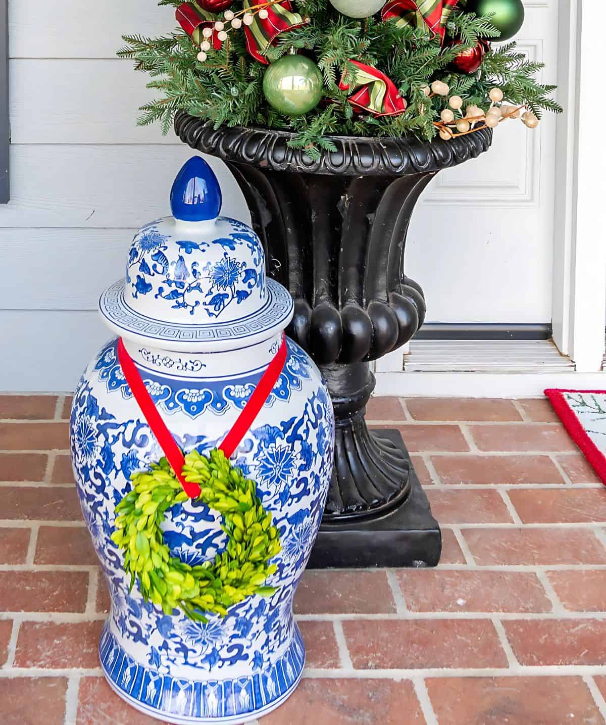 large blue and white ginger jar with a boxwood wreath