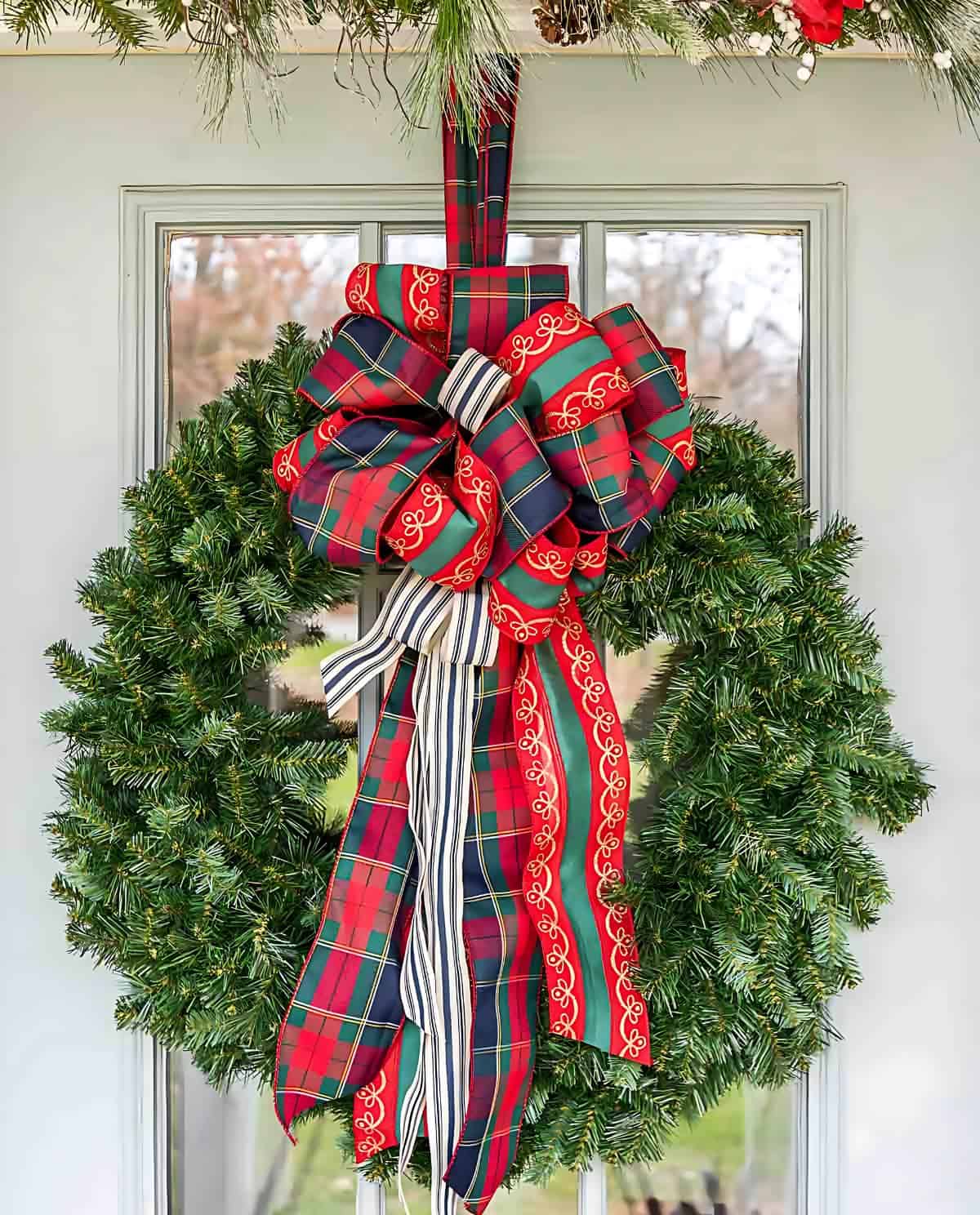 green Christmas wreath with a large plaid bow