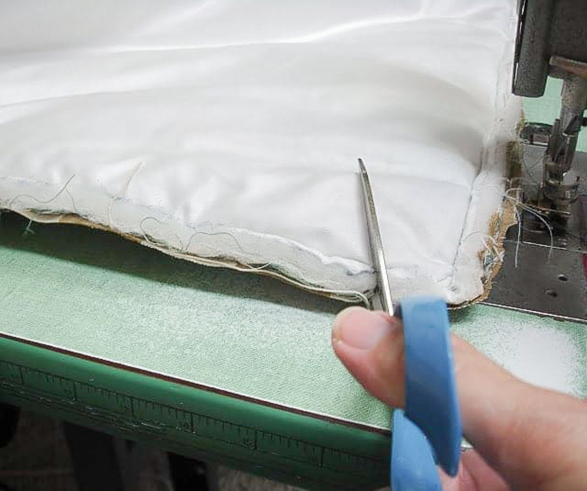 clipping the corner of a custom pillow sham with scissors