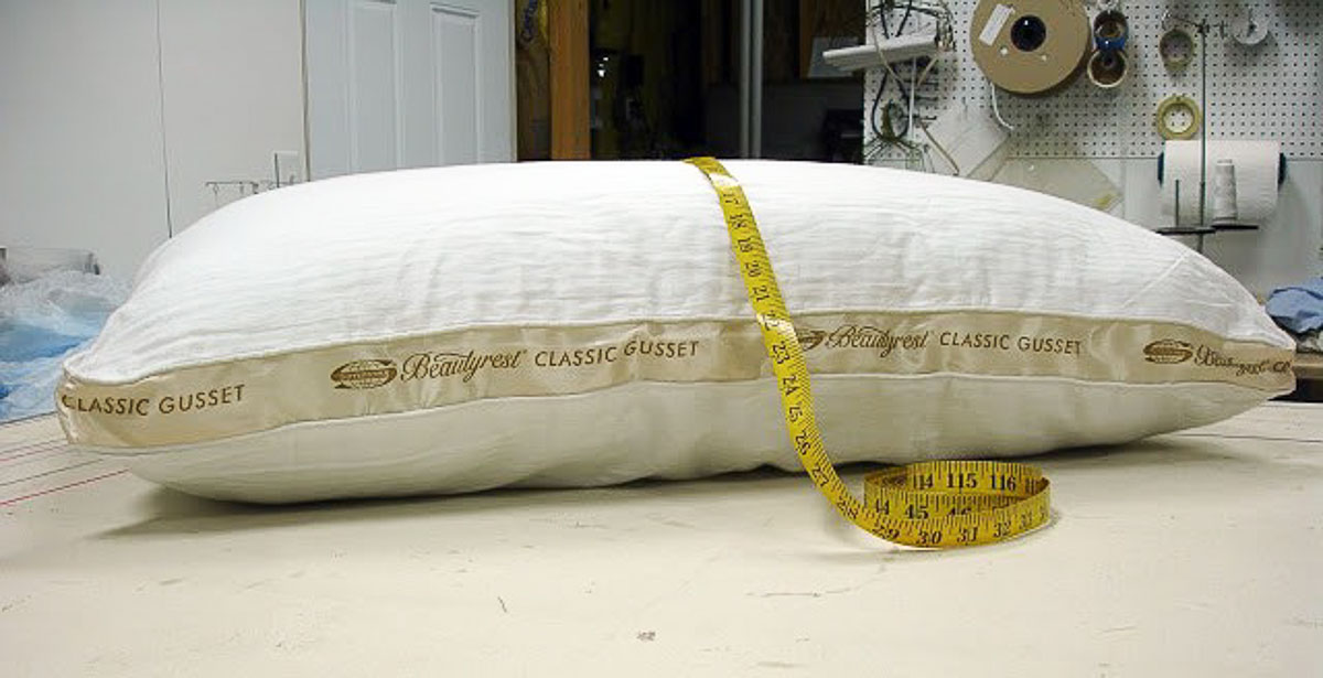 measuring tape lying across the top of a pillow to get the measurements for a custom pillow sham