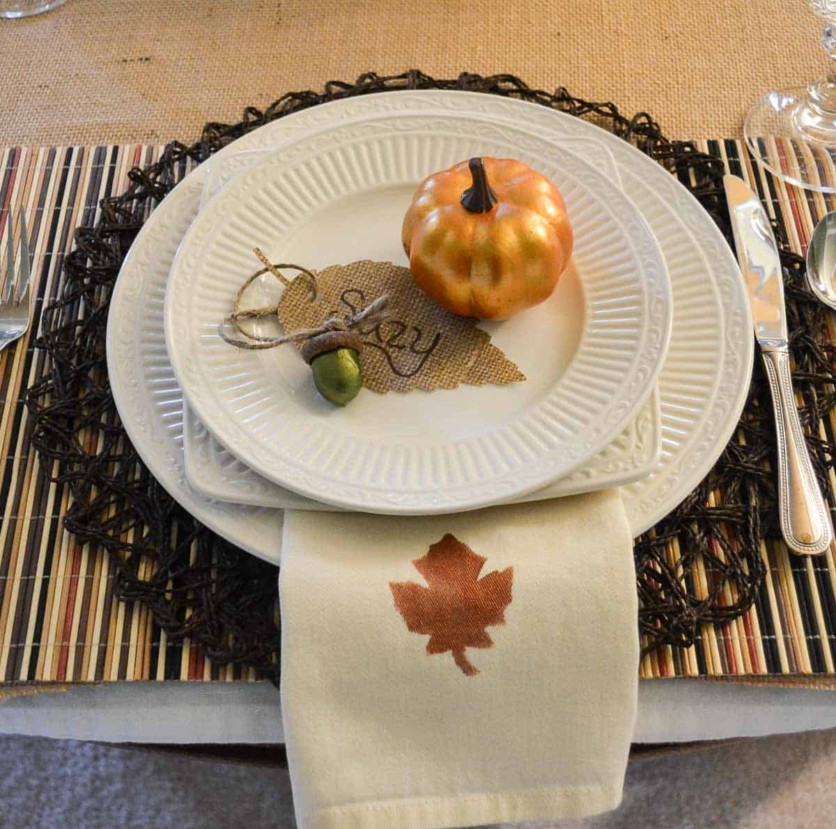 Thanksgiving tablescape with neutral linens, white dishes, and fall colored accents