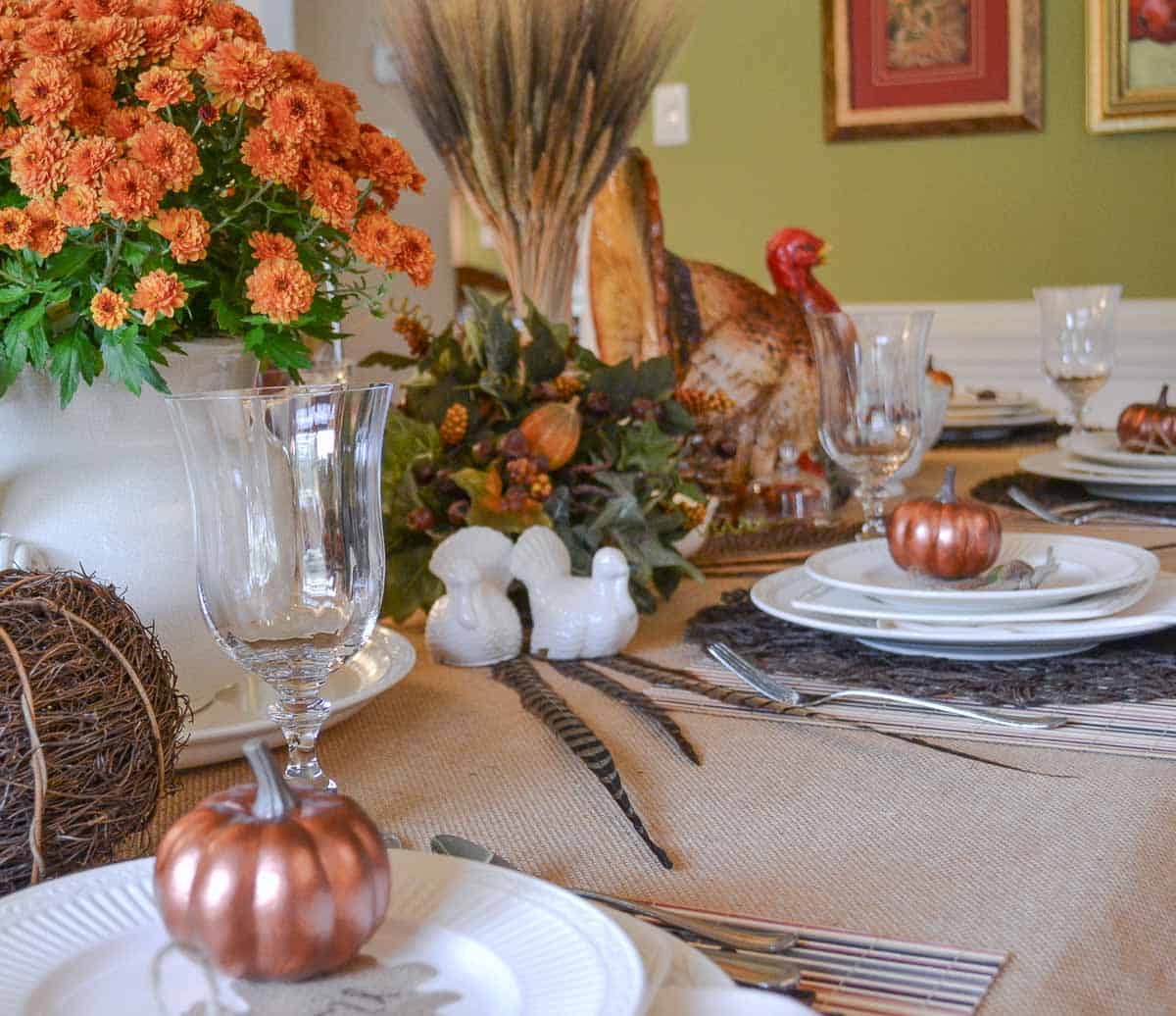 Thanksgiving tablescape with neutral linens, white dishes, and fall colored accents