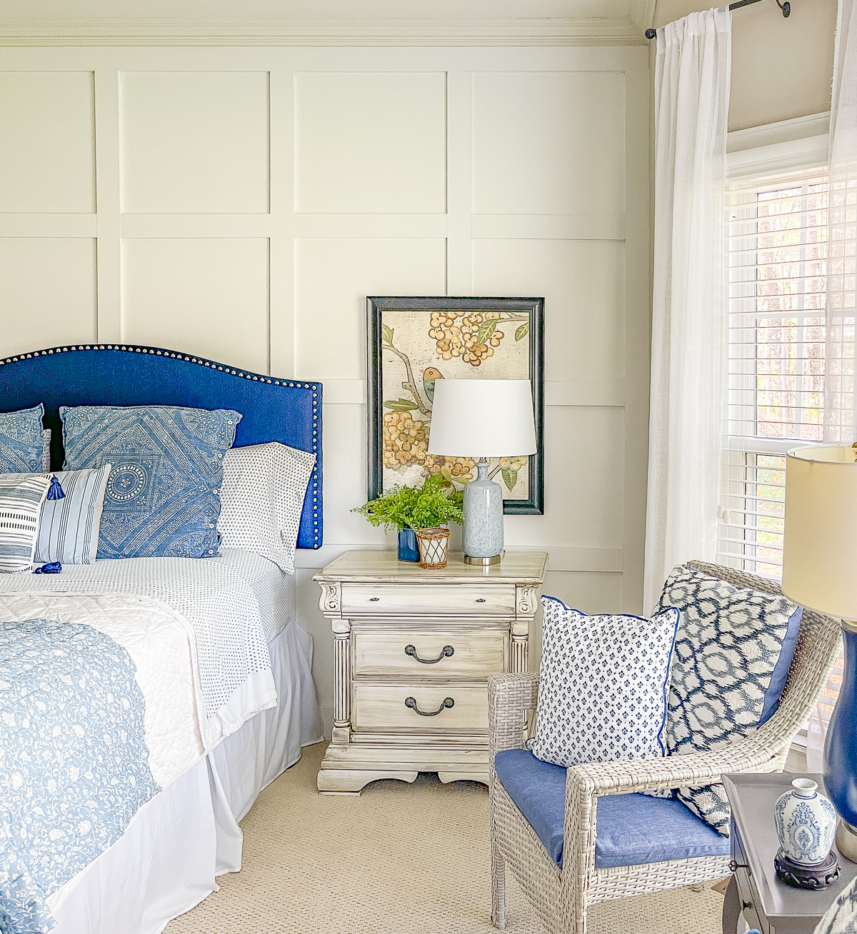 cottage style budget bedroom makeover with a navy blue upholstered headboard, board and batten feature wall, diy painted furniture and cottage style accessories
