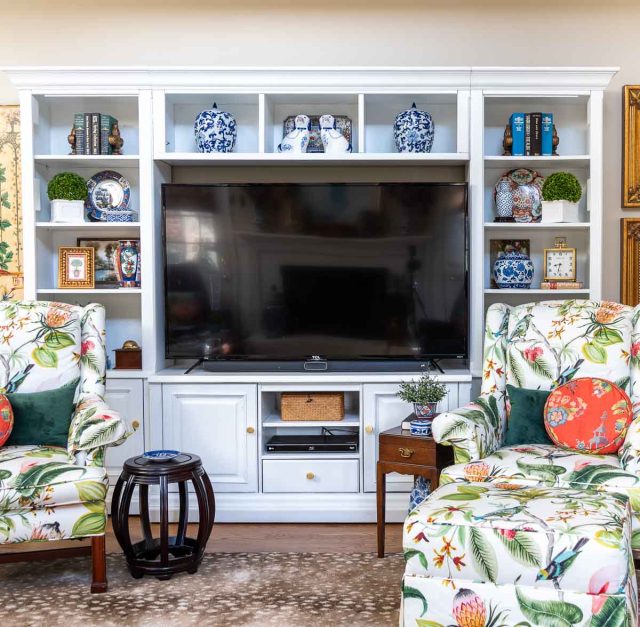 old entertainment center painted white and redecorated with updated traditional and chinoiserie accessories