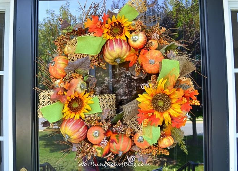 Couronne d'automne diy embellie avec des citrouilles, des tournesols et du ruban vert