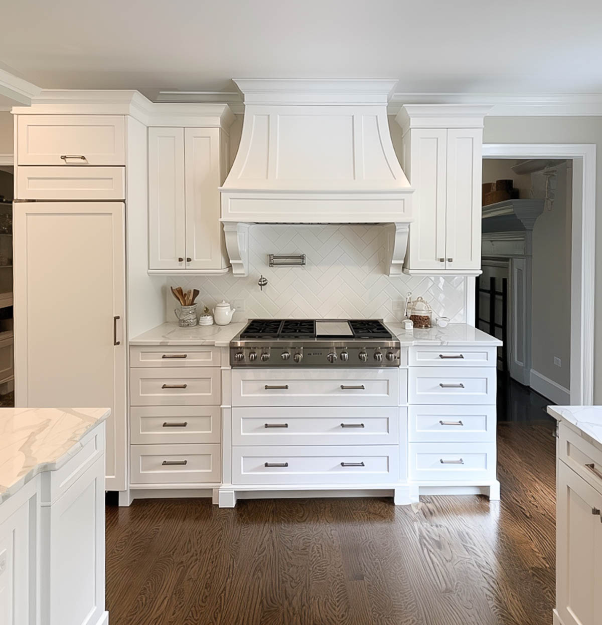 stove with a hood above it in a kitchen with white cabinets and hardwood floors