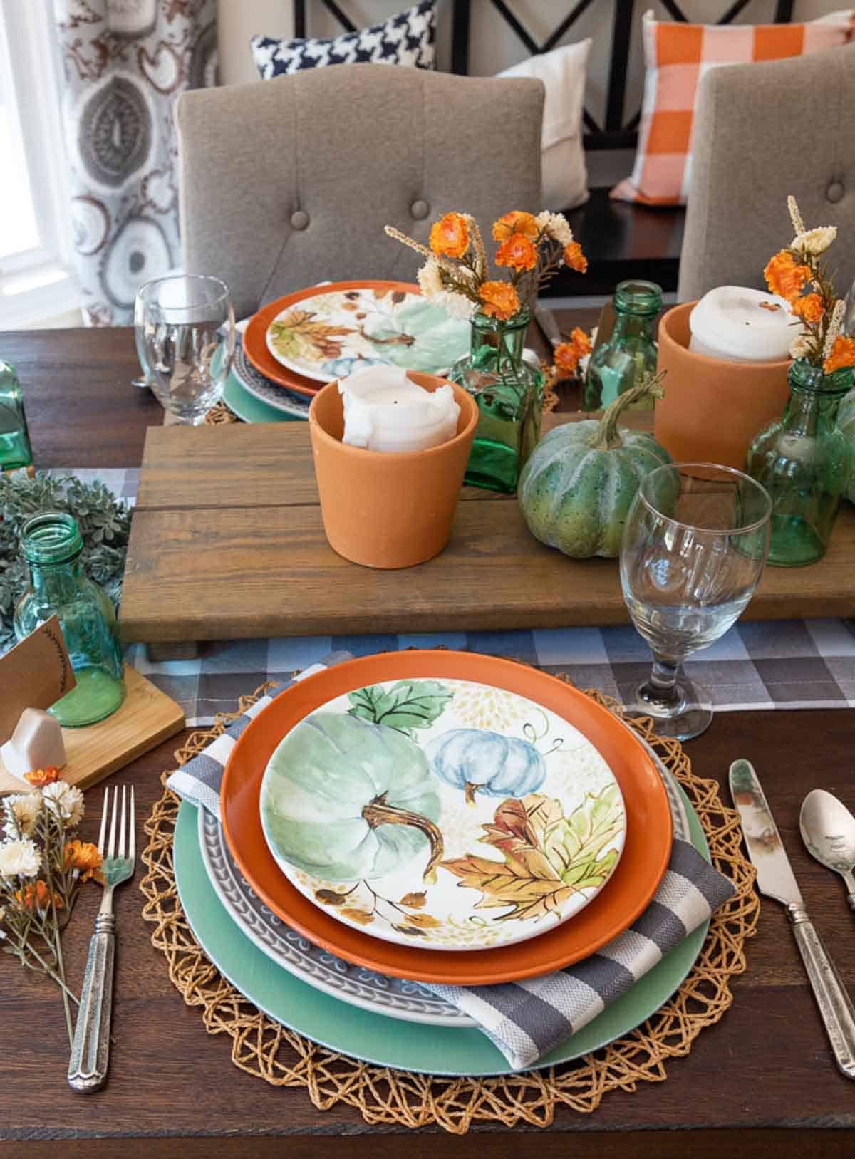 Table set for Thanksgiving with traditional fall colors and aqua as an accent color