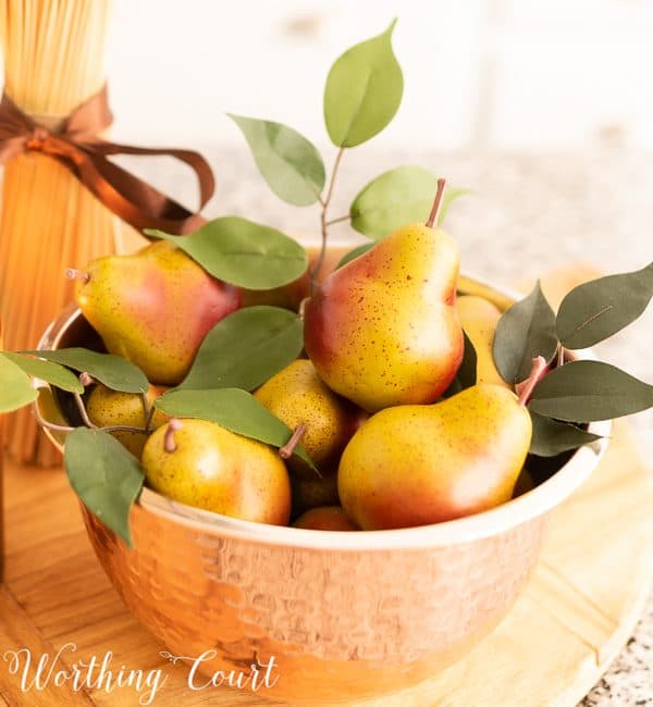 copper bowl filled with small faux pears for late summer decorating