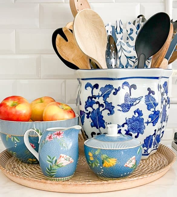 blue and white crock holding various cooking utensils display with blue sugar, creamer and bowl