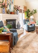 coice of antelope area rug in front of fireplace in a living room decorated in new traditional style with blue recliners, wood tables, colorful accessories