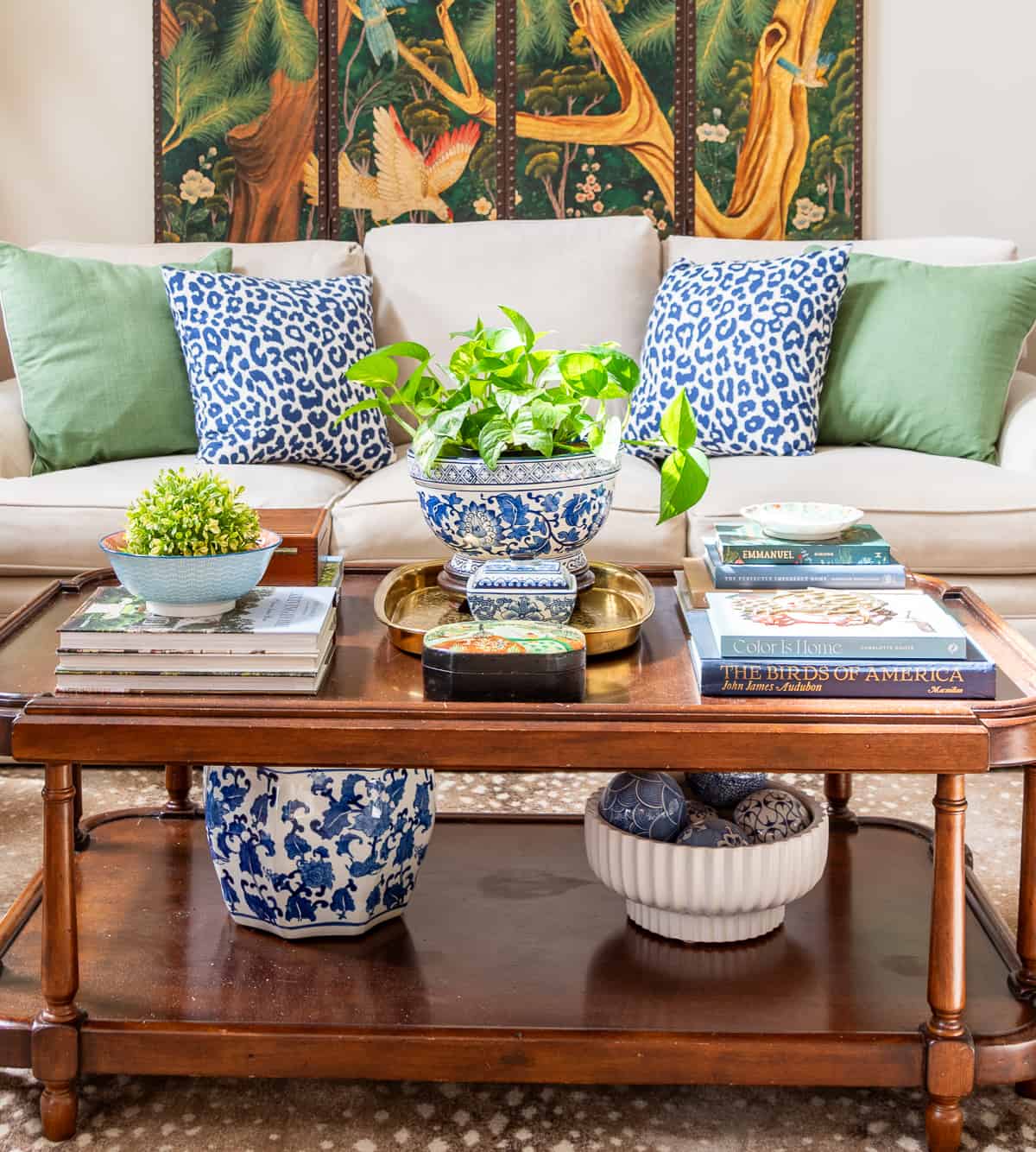 a variety of colorful accessories on a coffee table in front of a beige sofa in a new traditional style living room