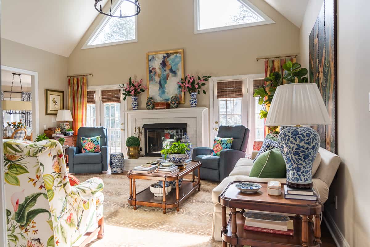 fireplace in a living room decorated in new traditional style with blue recliners, wood tables, colorful accessories and a faux antelope area rug