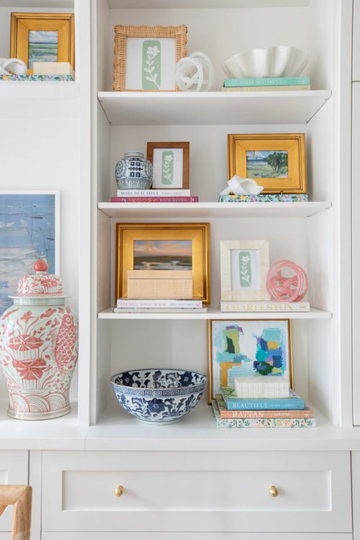 white bookcase filled with blue, white and pink chinoiserie accessories