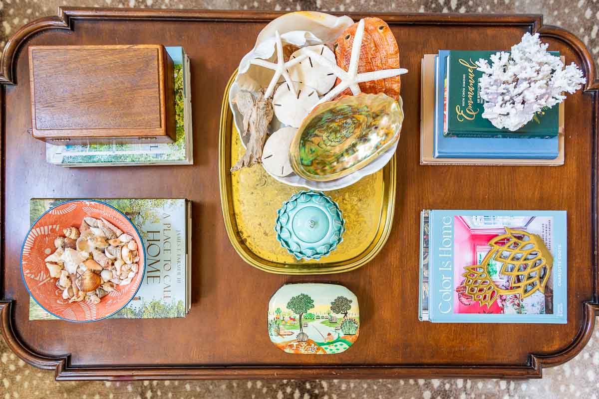 wood coffee table with colorful summer accessories and coffee table books