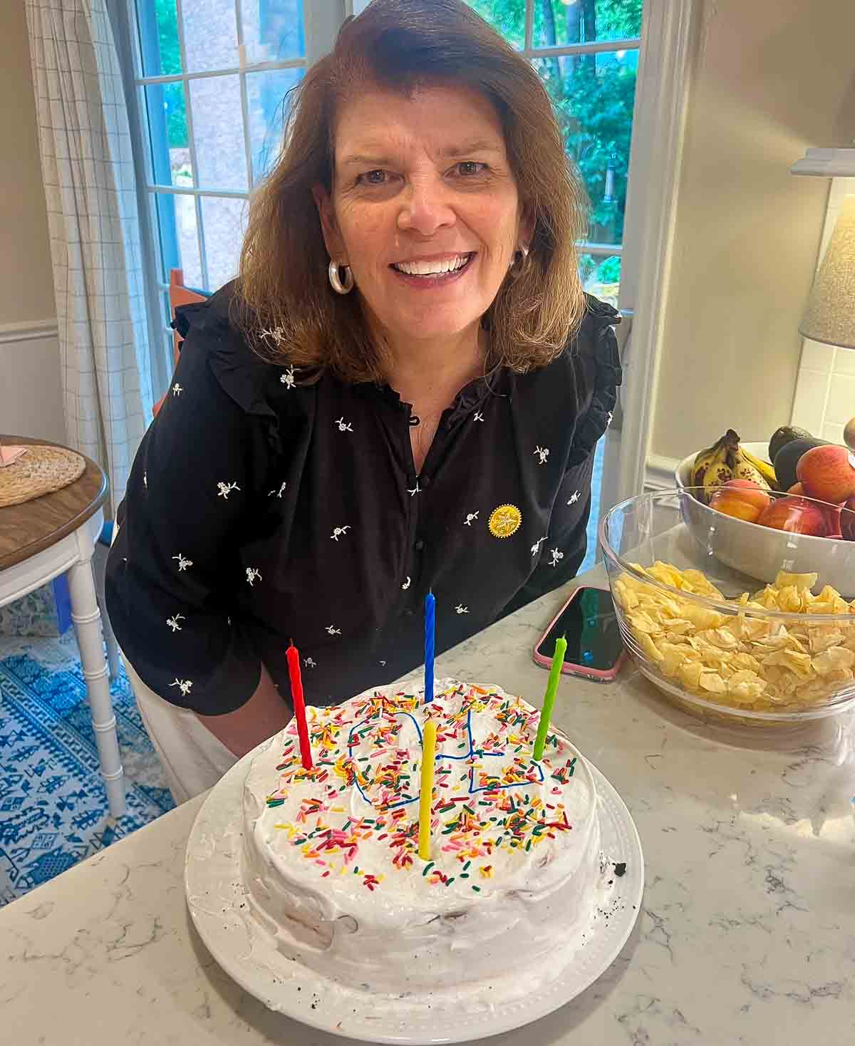 woman leaning over a birthday cake with candles