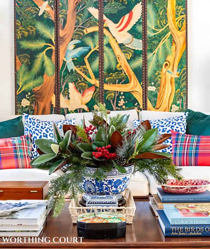 christmas greens arrangement on a coffee table in front of a sofa