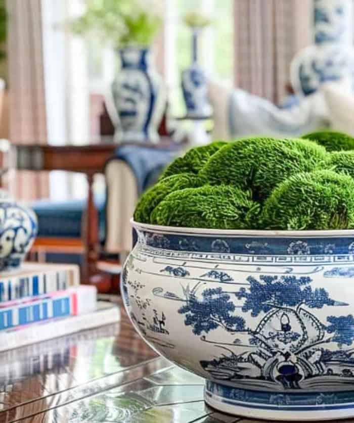 blue and white chinoiserie bowl fill with organic moss on a wood coffee table