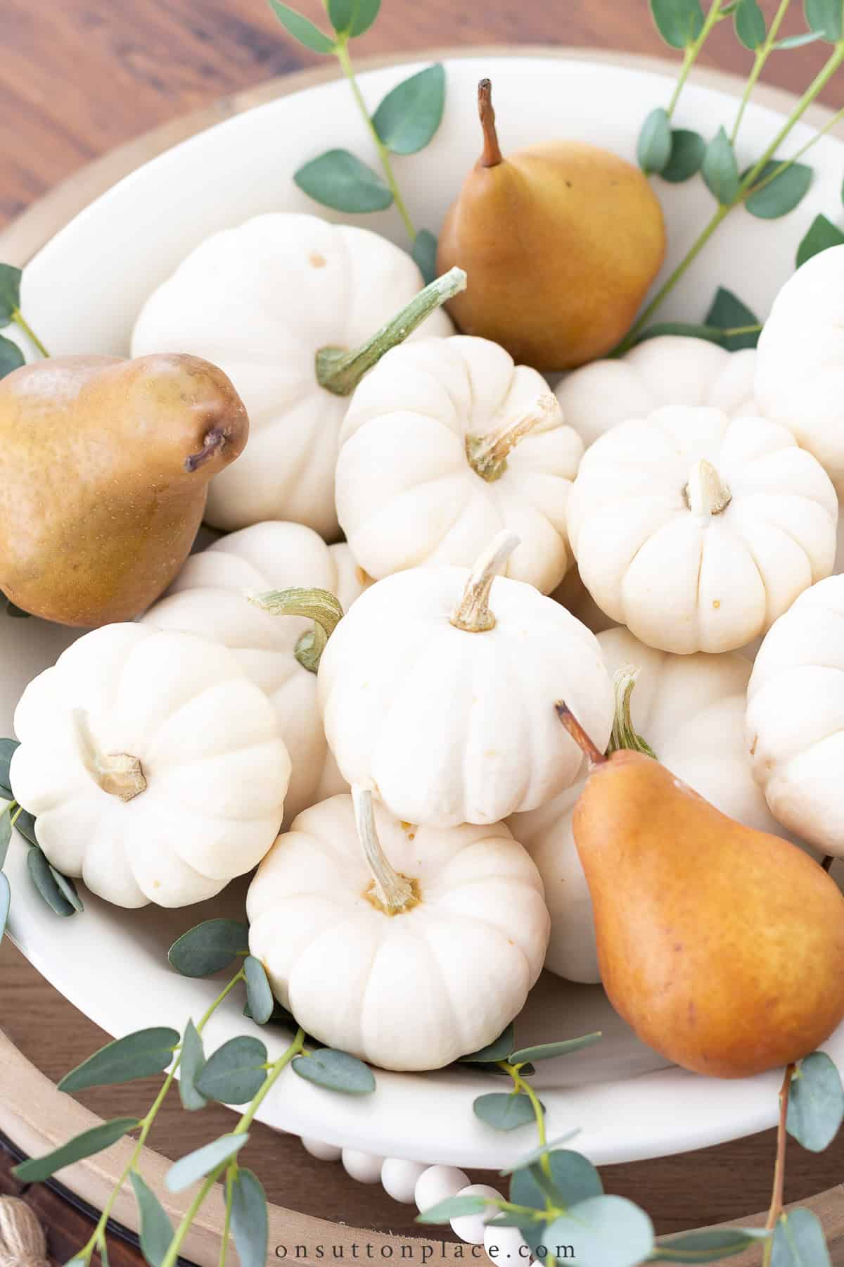 bowl of white mini pumpkins and brown pears