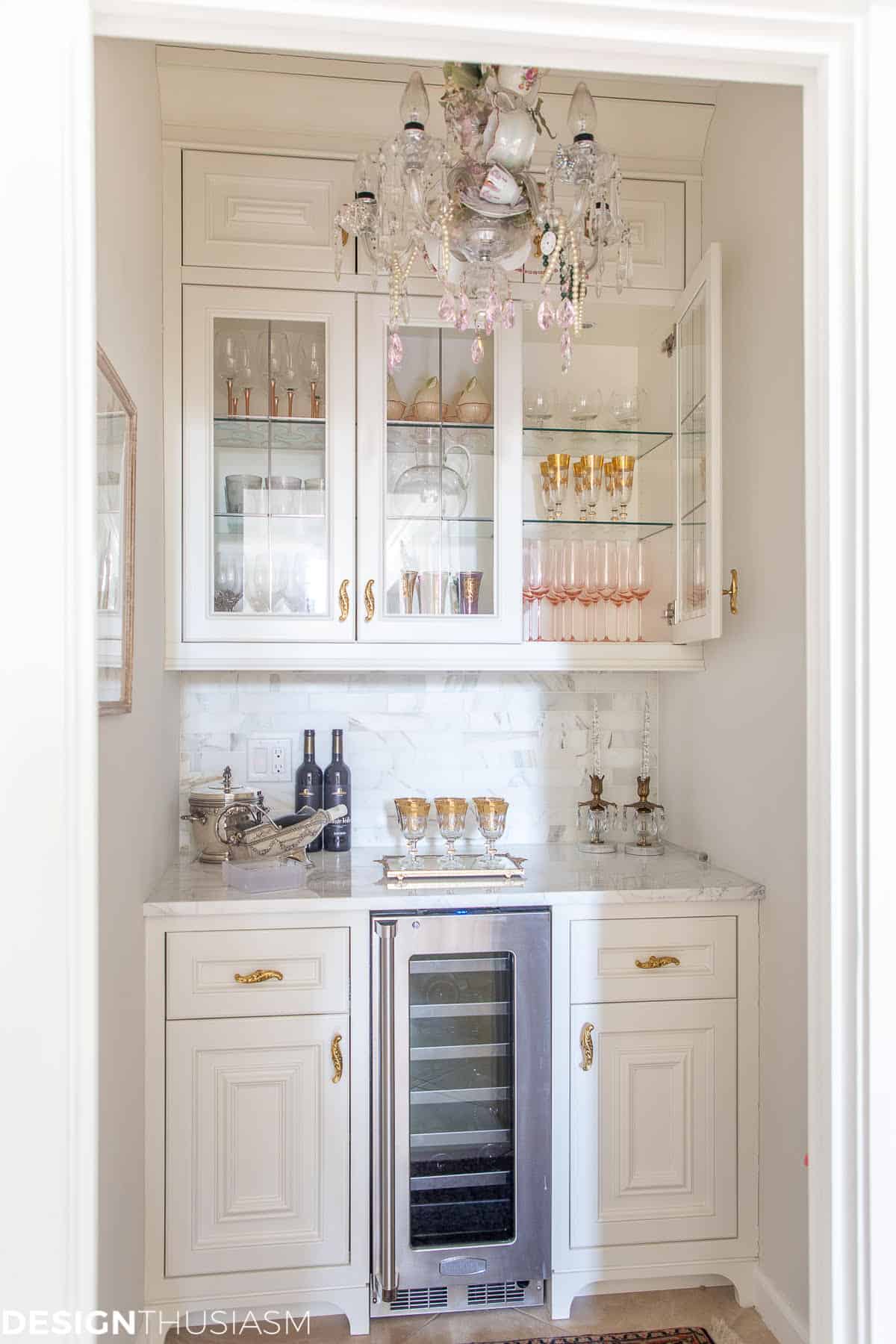 dry bar area with white cabinets and a mini fridge