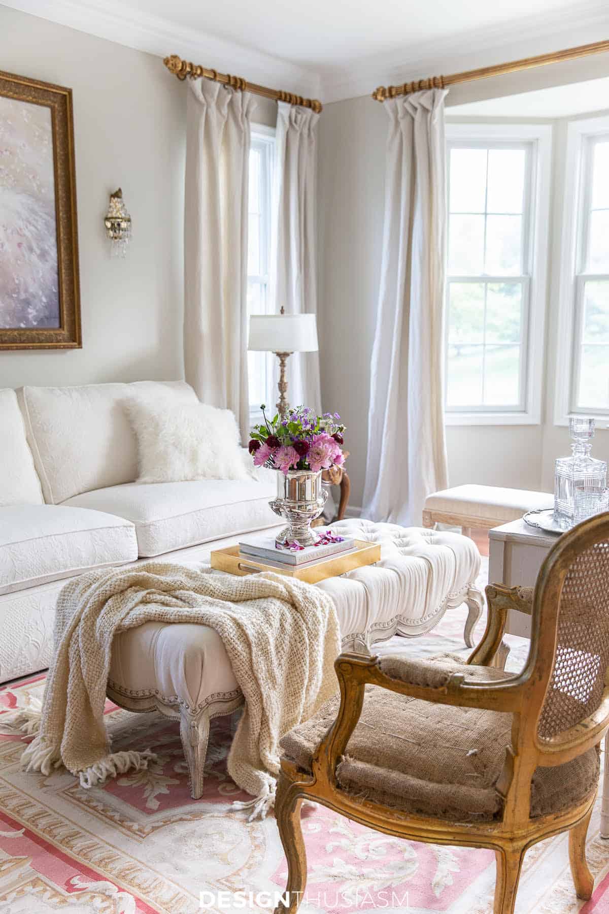 white sofa in a white room with a white throw thrown over an upholstered coffee table