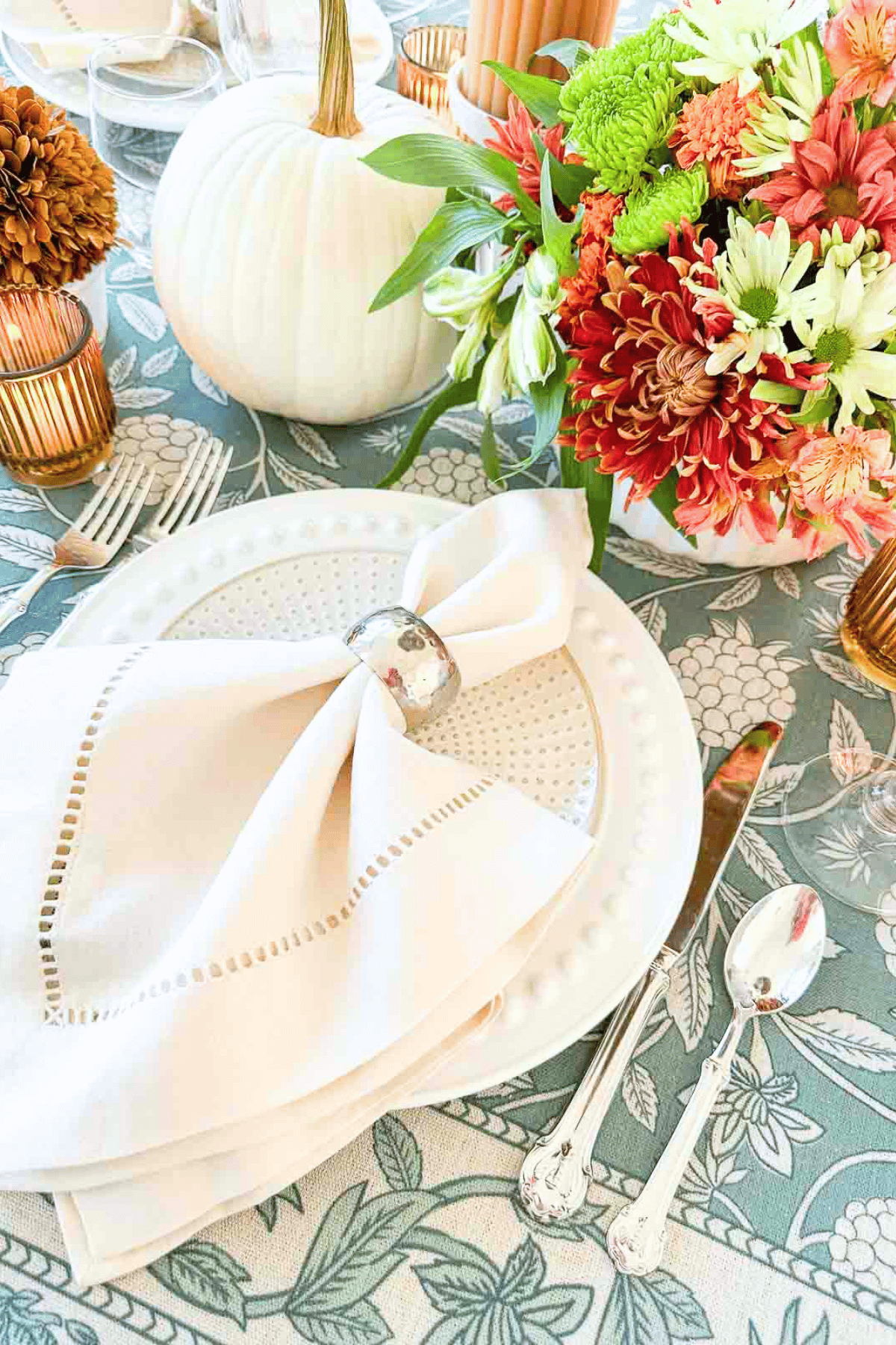 white thanksgiving place setting on a blue floral tablecloth