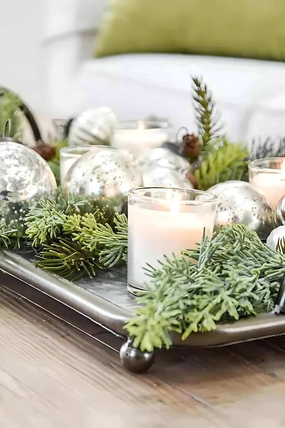 silver tray filled with greenery and white candles