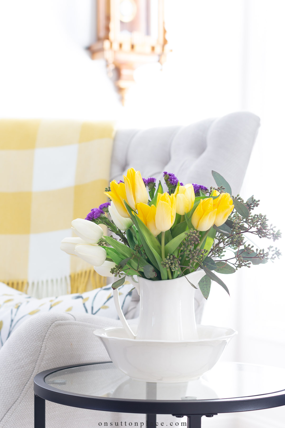 spring flowers in a white pitcher on a side table