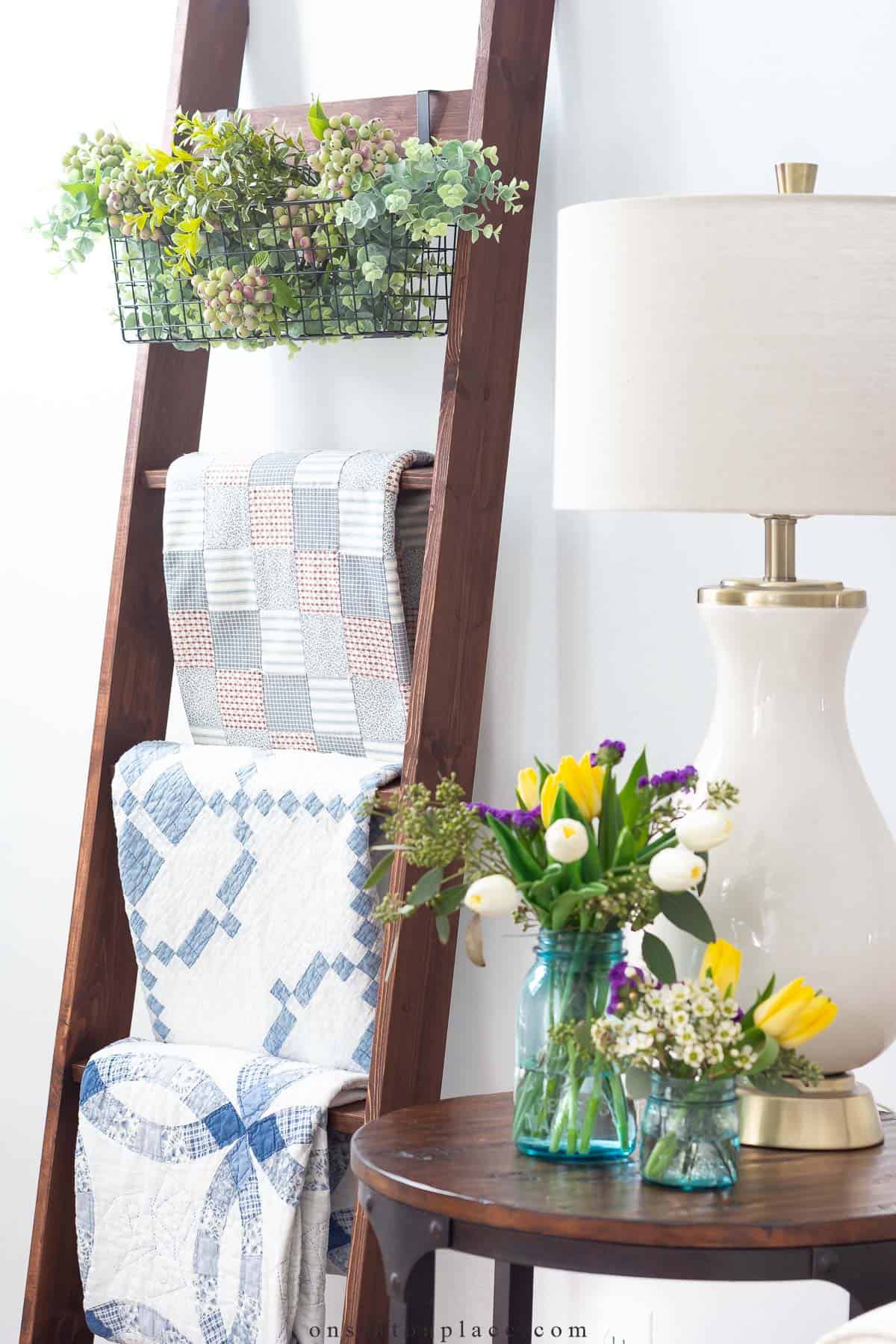 a quilt collection displayed on a wood ladder