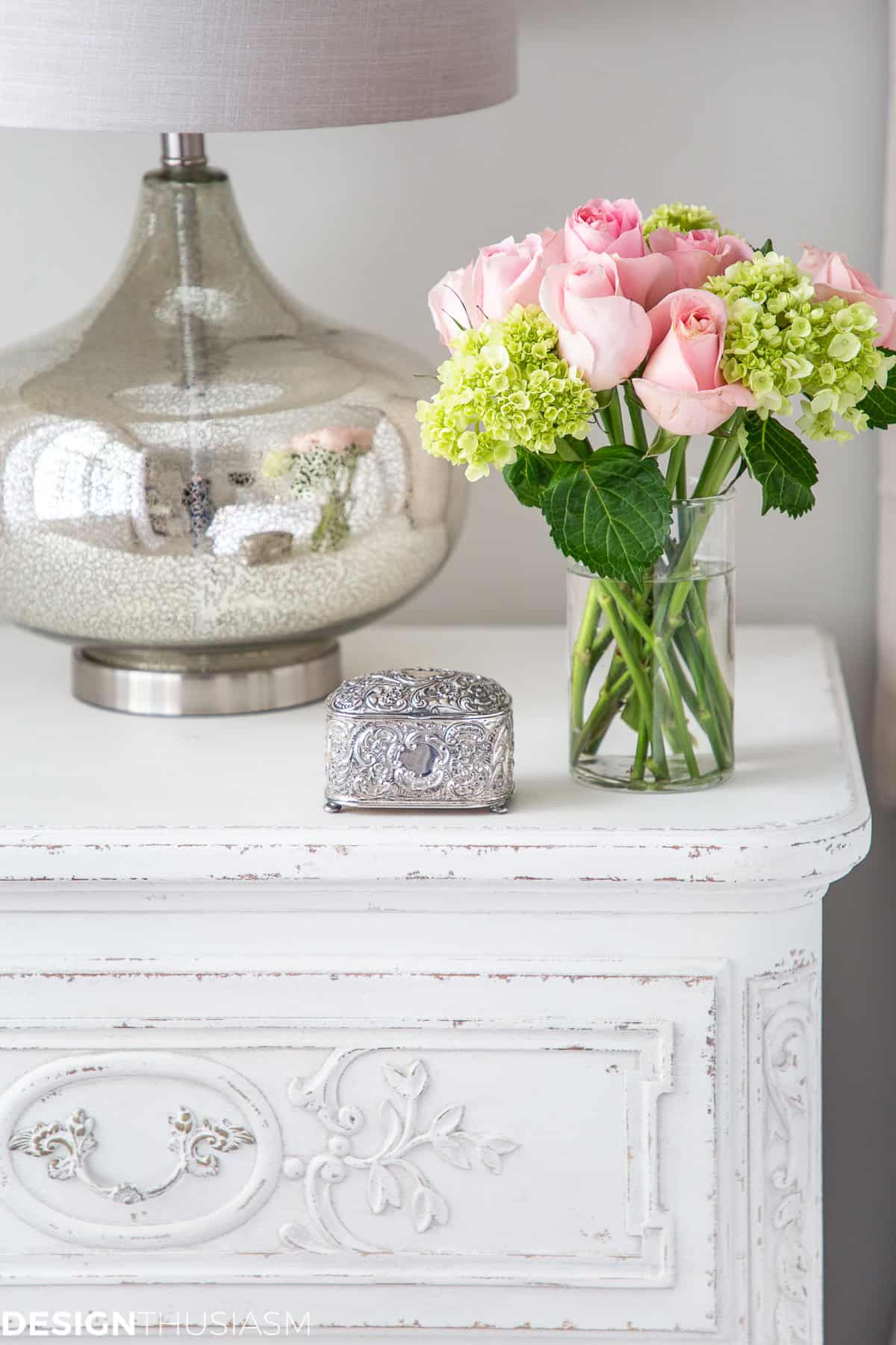 flower arrangement in a glass vase on a white end table