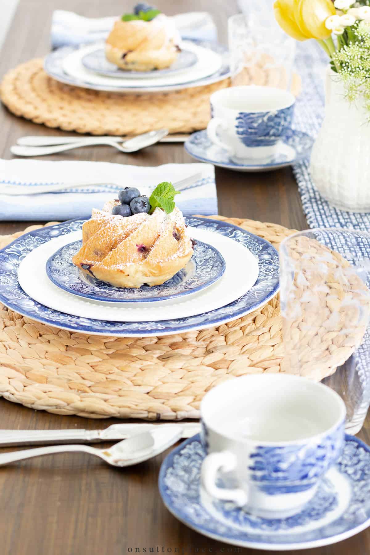 blue and white plates and cups on a raffia placemat