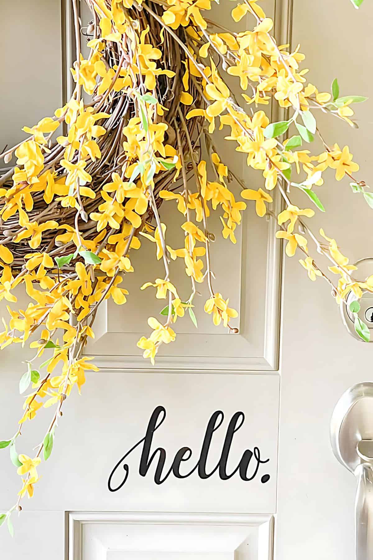 edge of a forsythia wreath on a beige door