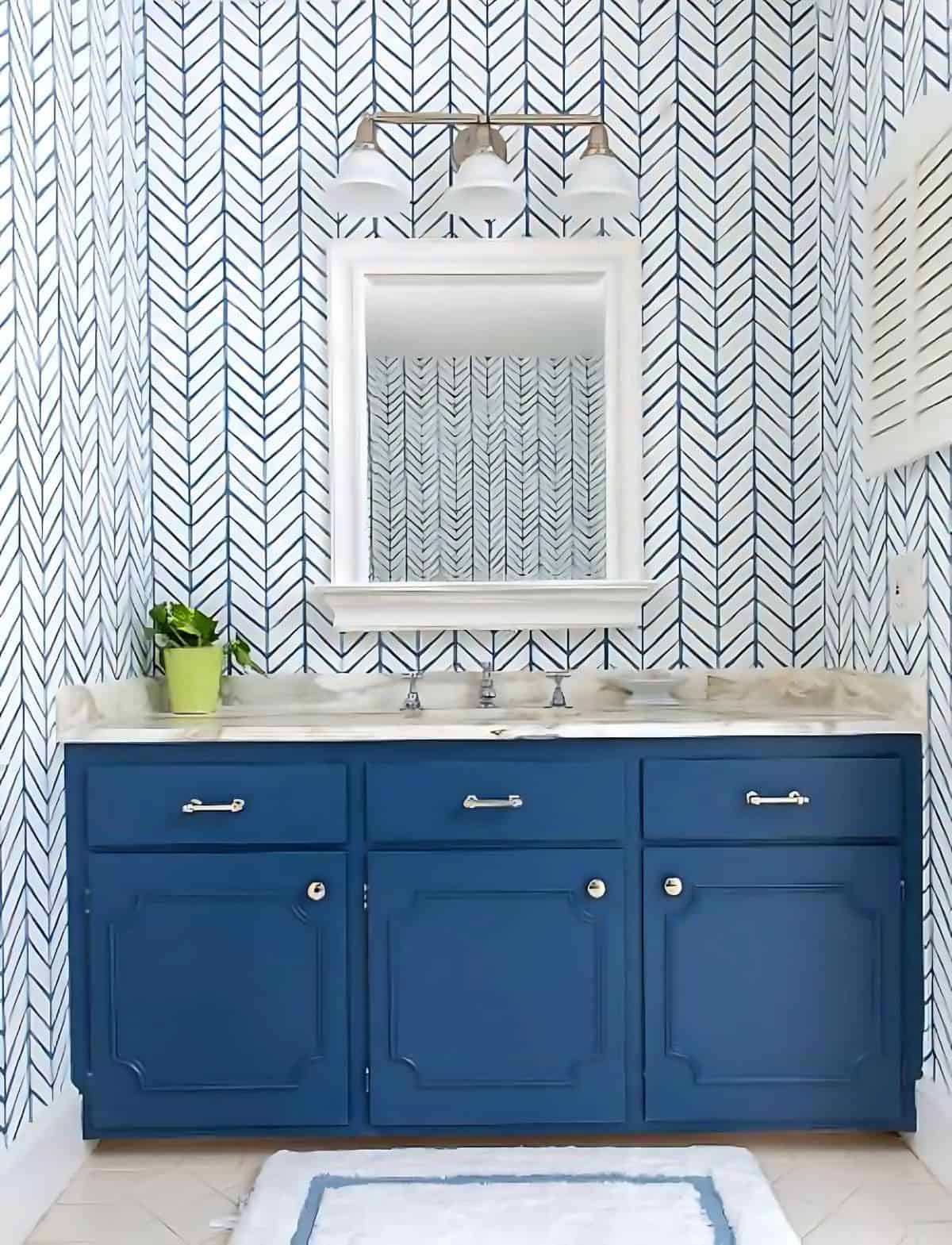 blue bathroom vanity in front of blue and white geometric wallpaper