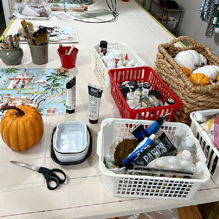 table filled with pumpkin painting supplies