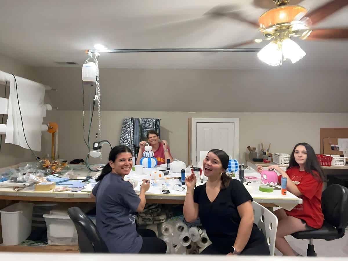 3 ladies painting pumpkins