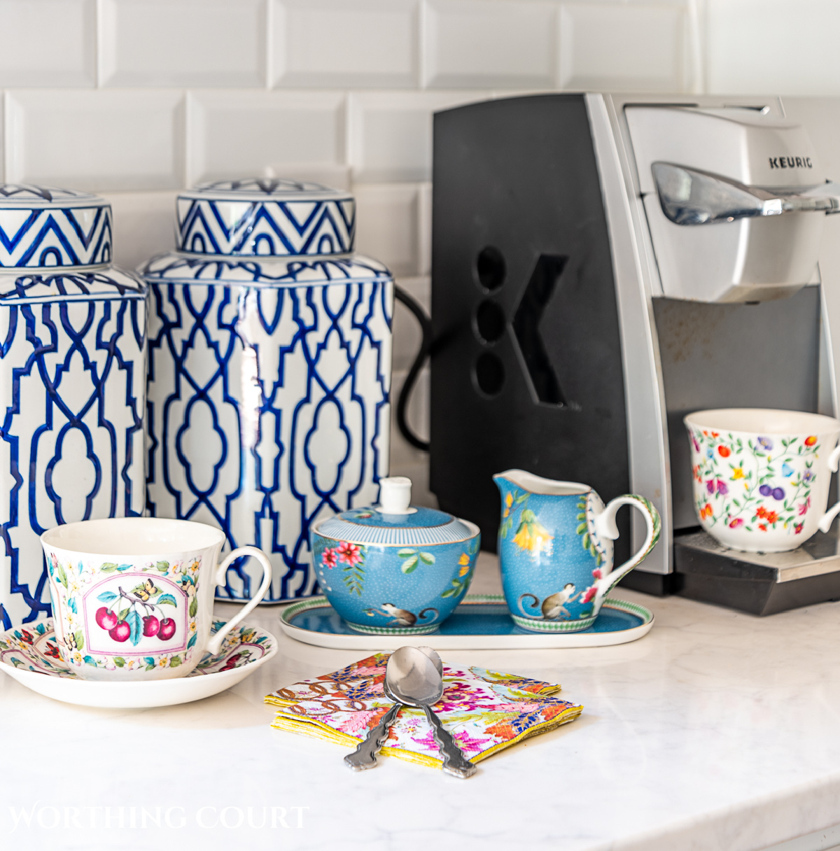 coffee maker with blue and white canisters and colorful cups