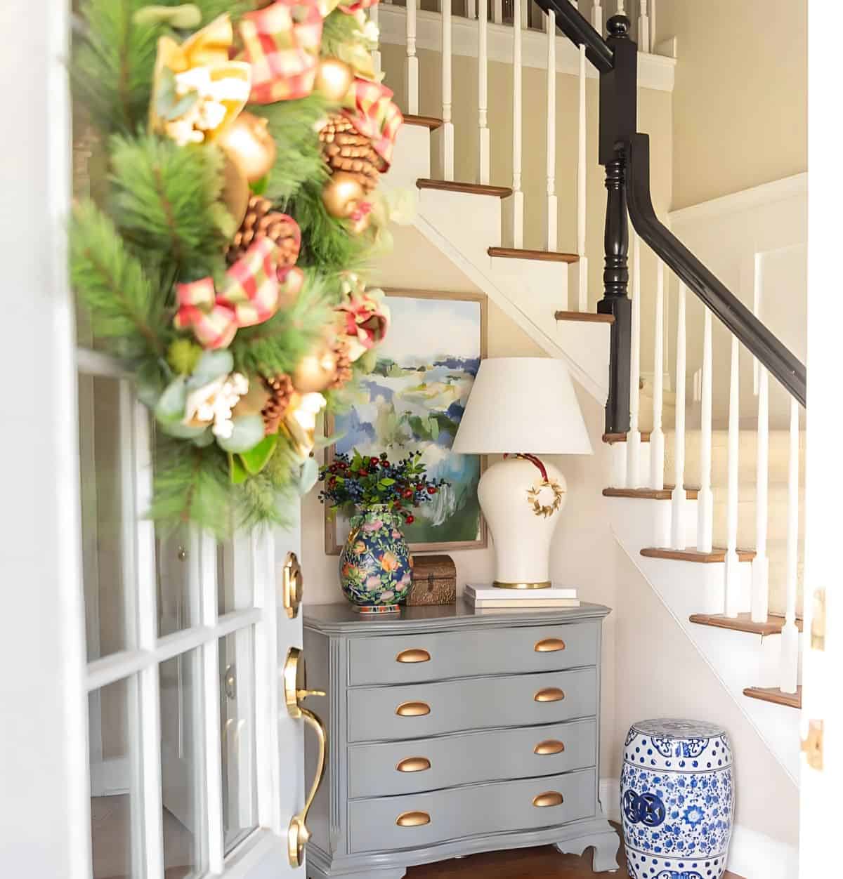 foyer with a gray chest decorated for Christmas