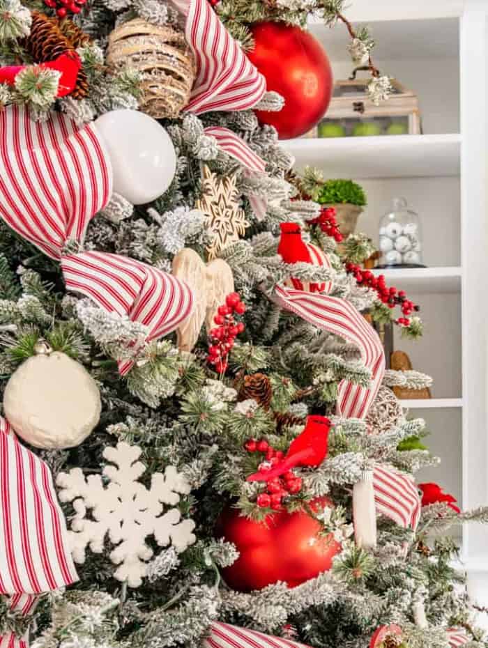 partial view of a Christmas tree with red and white decorations and ribbon