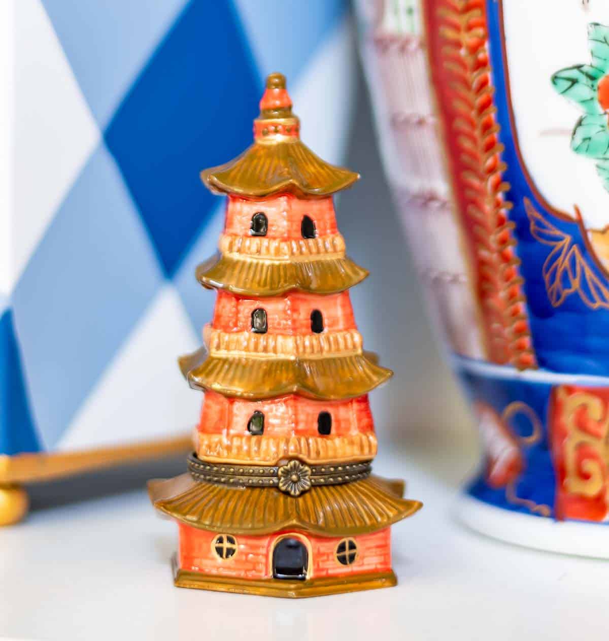 close up of an orange pagoda shaped enamel box