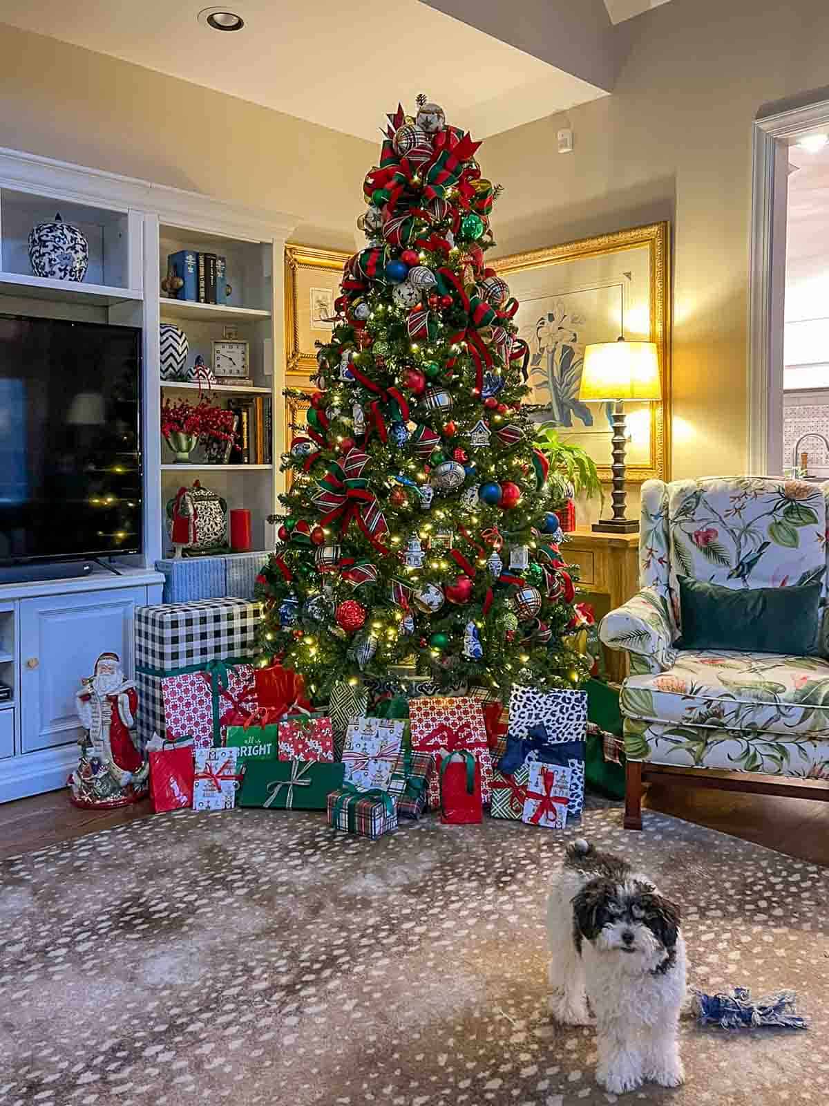 puppy standing in front of a Christmas tree