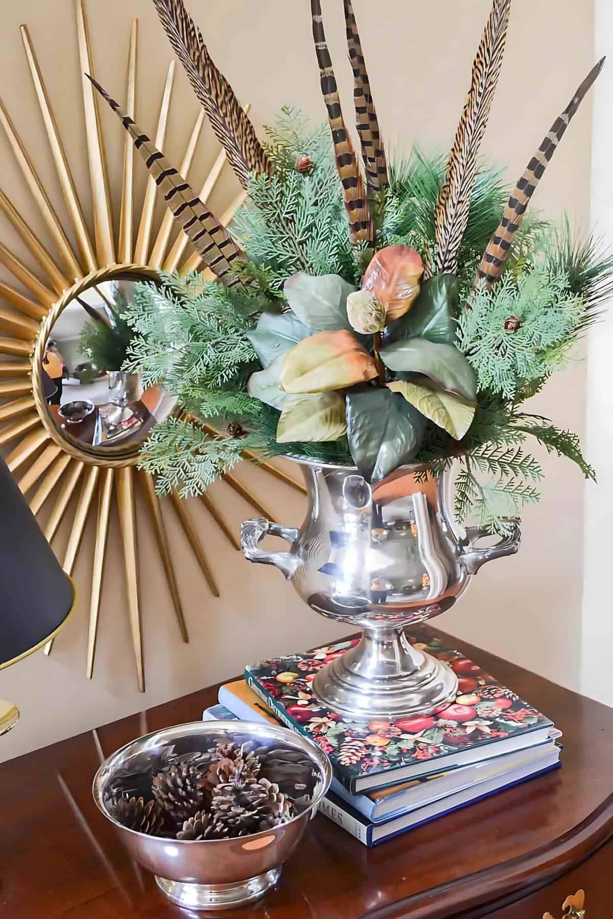 silver champagne bucket filled with Christmas greenery and feathers