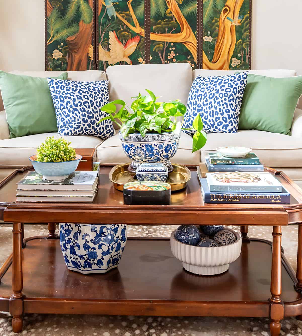 traditional wood coffee table with chinoiserie accessories in front of a netural sofa