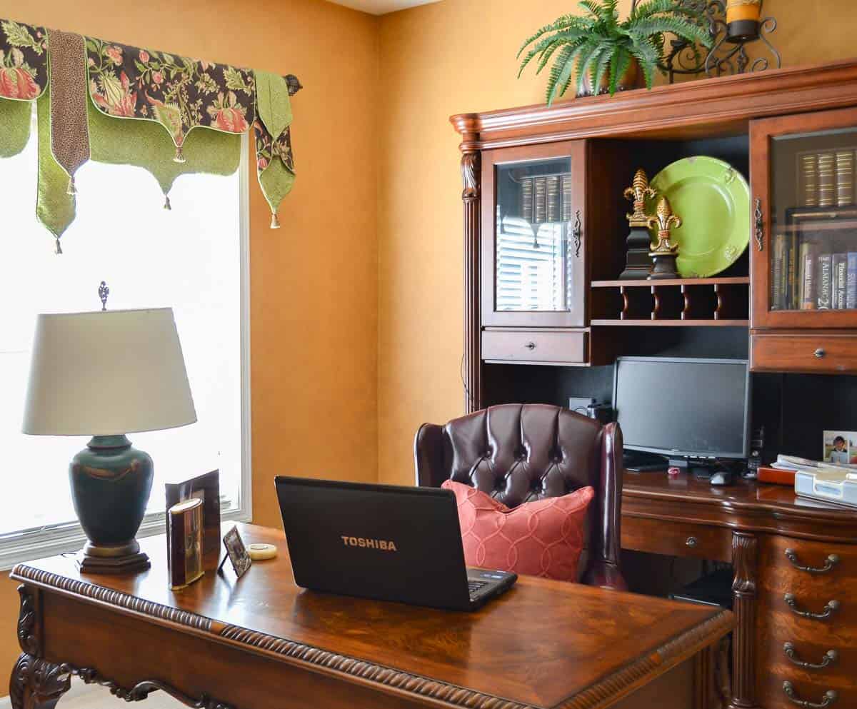 home office with side chairs, desk, file cabinet decorated with gold, green and red