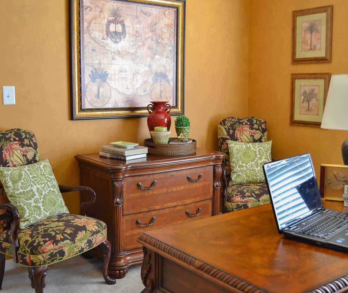 home office with side chairs, desk, file cabinet decorated with gold, green and red