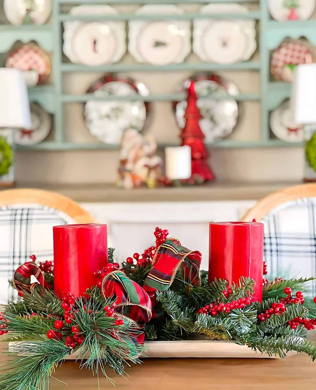 Christmas centerpiece with greenery and large red candles