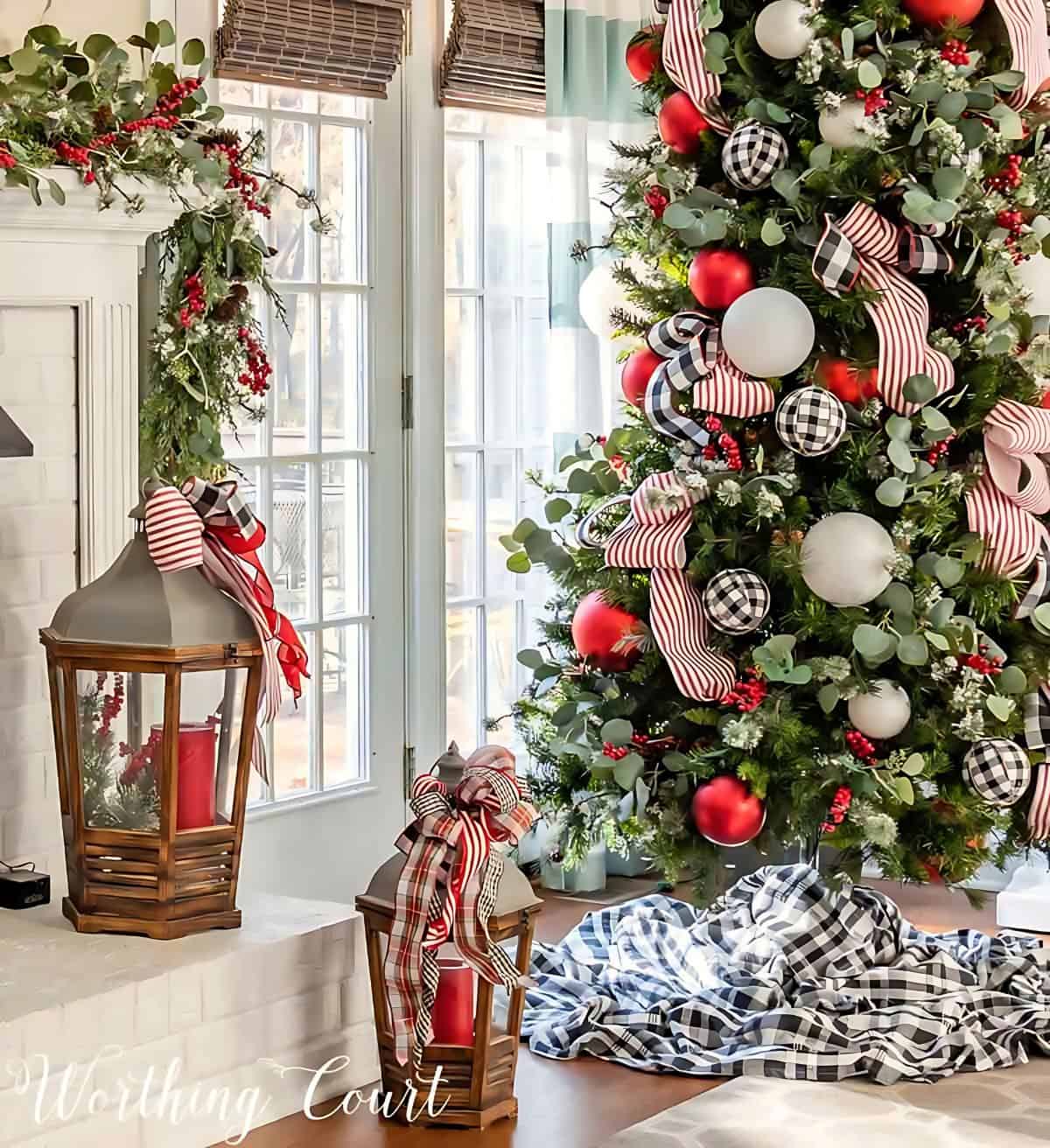 pair of lanterns on a hearth beside Christmas tree