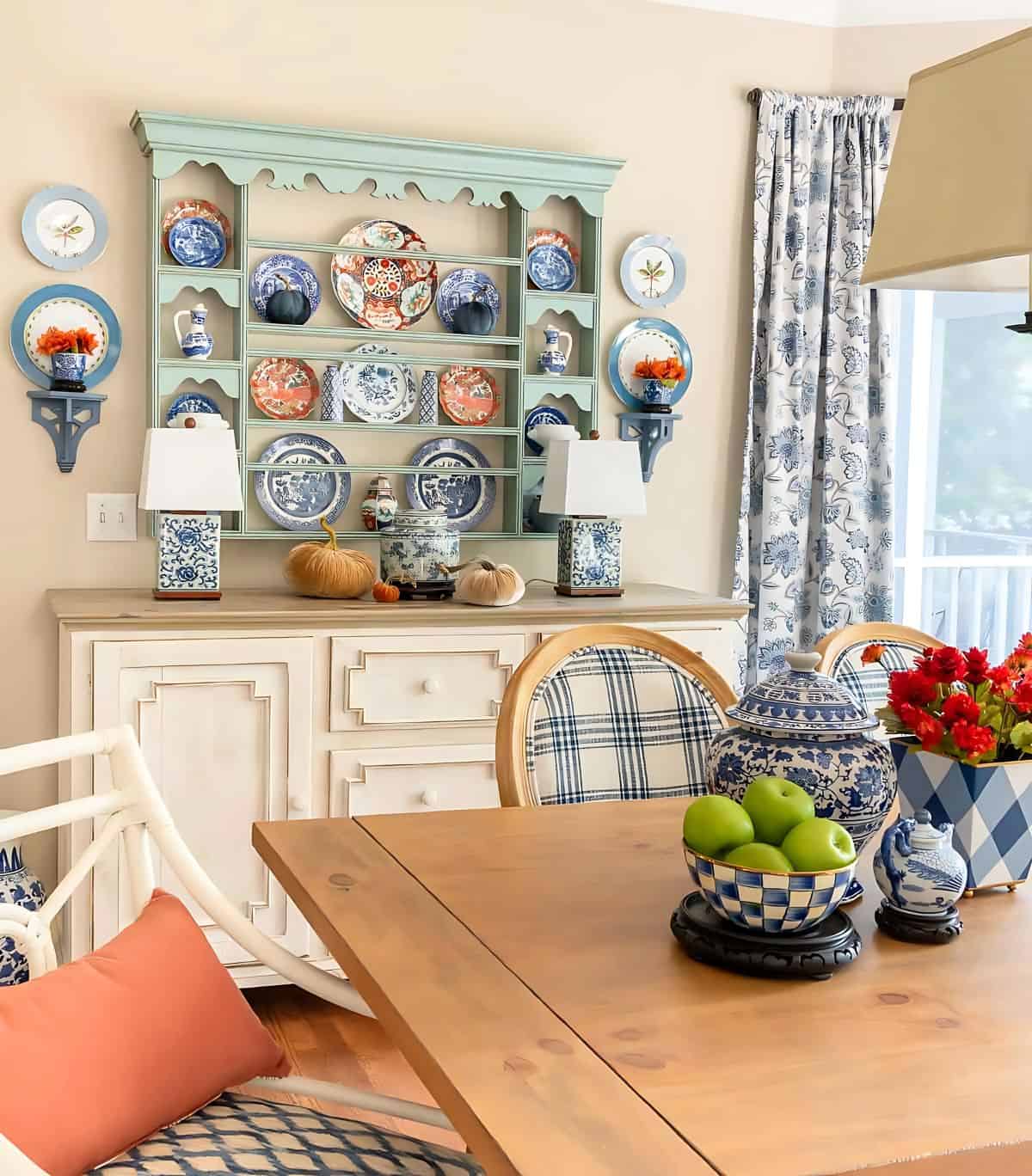 blue plate rack above a white sideboard decorated with blue and orange plates for fall